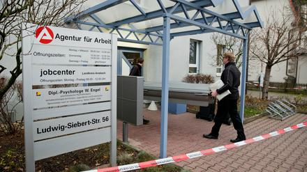 Mitarbeiter eines Bestattungsunternehmens tragen am 03.12.2014 in Rothenburg ob der Tauber (Bayern) einen Sarg in ein Jobcenter. Ein Mann hatte zuvor in dem Jobcenter einen 61-jährigen Mitarbeiter der Behörde erstochen.