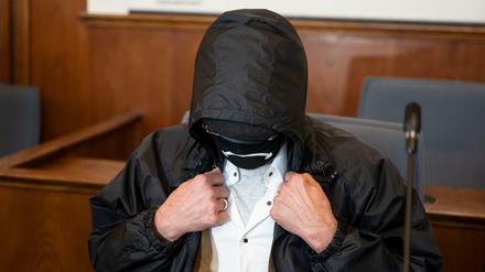 Der Angeklagte verbirgt auf der Anklagebank im Landgericht sein Gesicht hinter einer Gesichtsmaske, einer Brille und unter einer Kapuze. (Symbolbild)