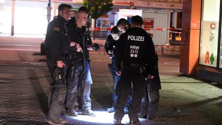 Polizisten suchen in der Nacht nach Spuren der Schießerei auf dem Hamborner Altmarkt in Duisburg.