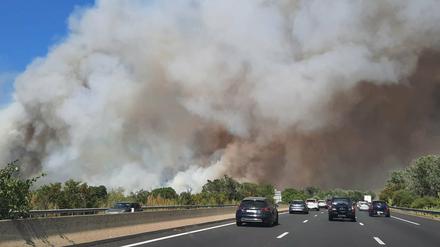 Frankreich, Aubais: Dichter weißer Rauch steigt neben einer Autobahn von einem Waldbrand auf.