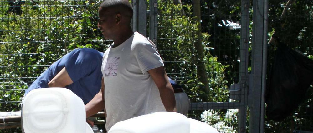Einwohner füllen Wasserkanister an einer natürlichen Quelle in Kapstadts Vorort Newlands auf.