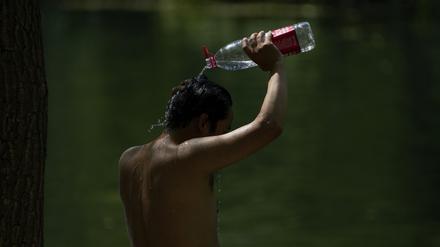 China, Peking: Ein Mann schüttet sich an einem heißen, schwülen Tag in der chinesischen Hauptstadt Wasser aus einer Flasche über den Kopf.