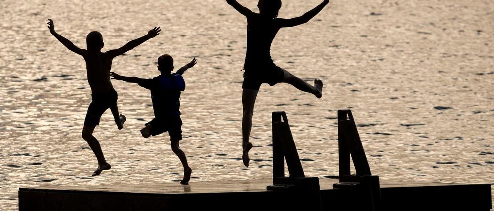 Kinder springen von einer Schwimminsel (Symbolfoto).