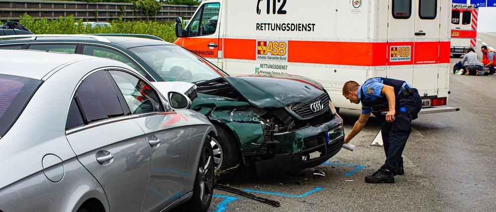 Rettungskräfte stehen am Sonntag an der Unfallstelle auf der Autobahn 3 bei Wiesbaden. Ein illegales Wettrennen soll zu einer Massenkarambolage geführt haben.