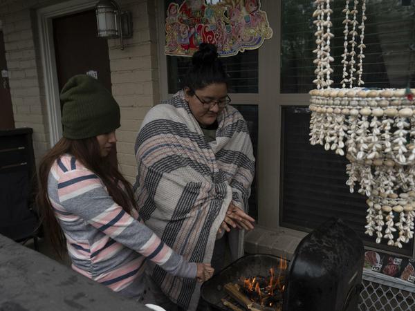 In Houston wärmen sich zwei Frauen an einem Barbecue-Grill.