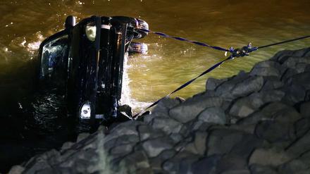 Rettungskräfte bergen das versunkene Auto aus dem Rhein.