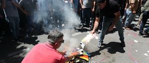 Anti-LGBT-Demonstrant:innen verbrennen eine Regenbogenfahne in Tiflis. 