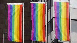 Regenbogenflaggen hängen vor einem Gebäude (Symbolbild).