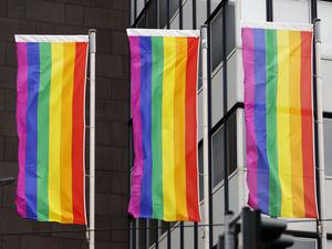 Regenbogenflaggen hängen vor einem Gebäude (Symbolbild).
