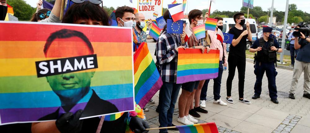 Wegen seiner homophoben Wahlkampagne wird Präsident Andrzej Duda von LGBT-Demonstranten aufgefordert, sich zu schämen.