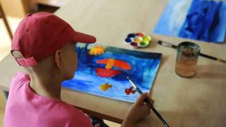 Ein acht Jahre altes Mädchen malt nach seiner erste Bestrahlung ein Bild.