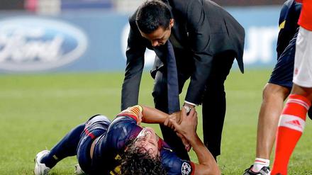 Carles Puyol windet sich vor Schmerzen nach seinem Sturz beim Champions-League-Match gegen Benfica Lissabon.