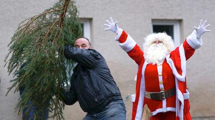 Sieht nach manischer Phase aus: Ein Weihnachtsmann feuert beim Tannenweitwurf an.
