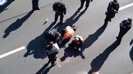 Aktivisten werden von Polizisten von der Stadtautobahn gelöst.
