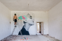 Street-Art-Künstler KoeOne malt hier gerade ein Bild in einem Gebäude der artbase.