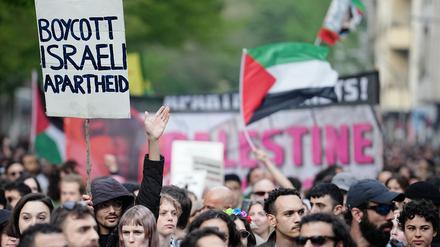 Demonstranten halten am 1. Mai 2023 in Berlin ein Plakat mit der Aufschrift „Boycott Israeli Apartheid“ hoch.