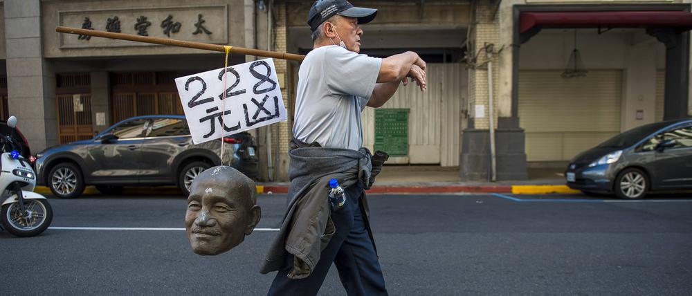 Ein Demonstrant erinnert in Taipeh an das 228-Massaker, bei dem die KMT 1947 bis zu 28.000 Taiwanesen tötete. Auf dem Schild über dem Chiang-Schädel steht „Haupttäter“.