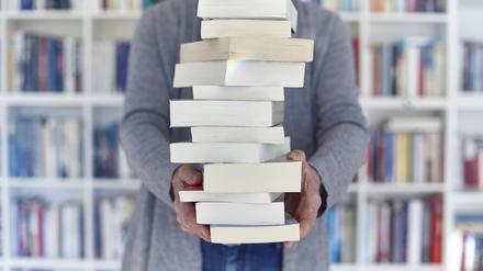 Eine Frau hält einen Bücherstapel.