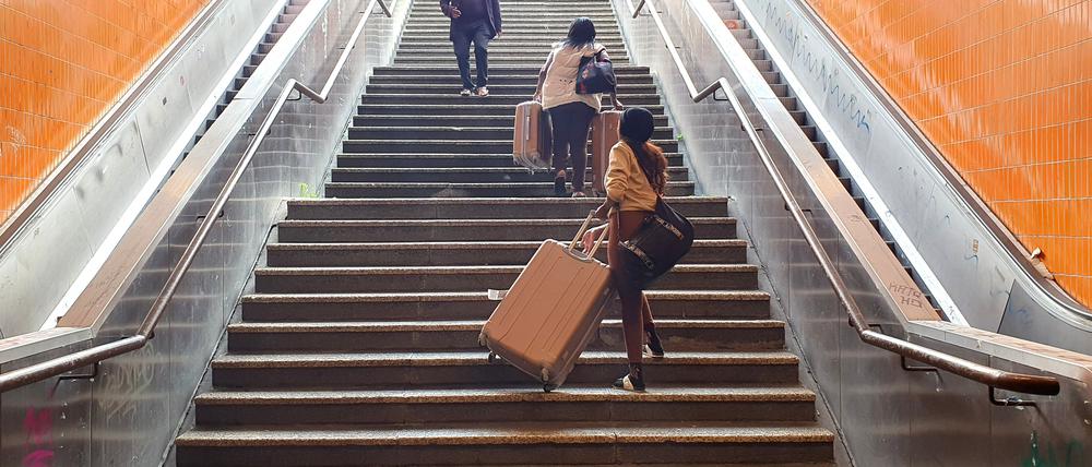 Teilnehmer der „Special Olympics“ müssen schwere Koffer die Treppen hochschleppen.