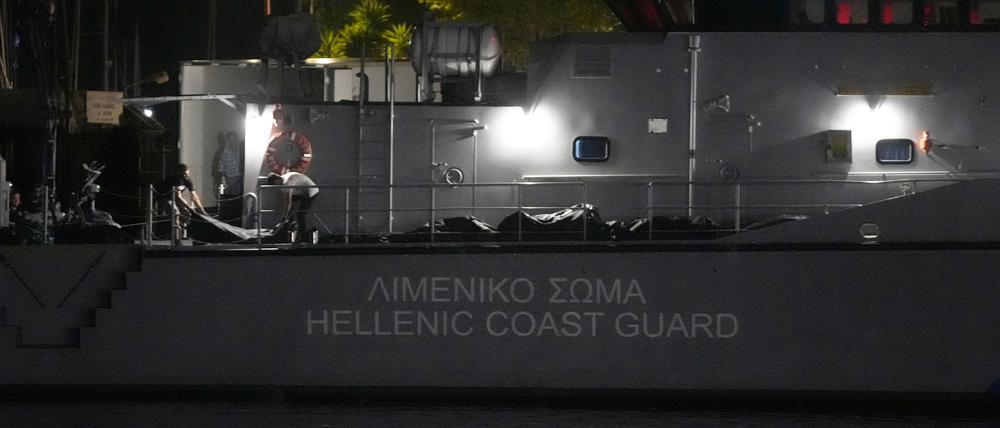 Rettungskräfte tragen Leichen von einem Schiff der Küstenwache in einen Kühlwagen im Hafen von Kalamata, etwa 240 Kilometer südwestlich von Athen.