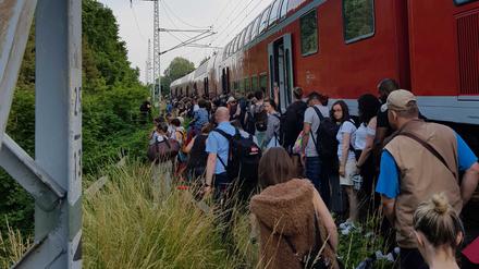 Passagiere steigen auf offener Strecke in der Nähe des FEZ aus dem liegengebliebenen Regionalexpress 2 aus.