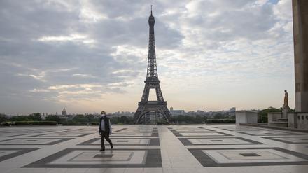 Ein Passant auf dem Trocadero-Platz mit Blick auf den Eiffelturm trägt einen Mundschutz.