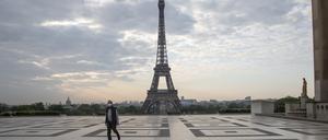 Ein Passant auf dem Trocadero-Platz mit Blick auf den Eiffelturm trägt einen Mundschutz.