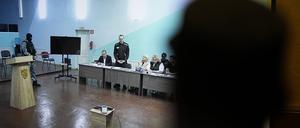 Ein Beamter steht vor einem Monitor, der eine Live-Übertragung aus dem Verhandlungssaal zeigt, in dem Alexej Nawalny (3.v.l), Oppositionspolitiker aus Russland, während einer vorläufigen Anhörung in der Strafkolonie Melechowo spricht.
