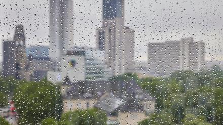 Regentropfen sind an einer Fensterscheibe vor der Skyline der City West zu sehen.
