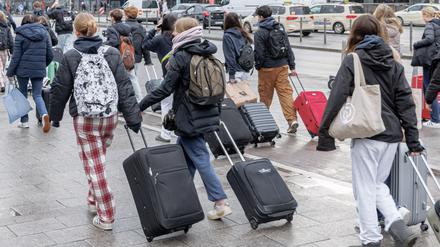 Schüler auf Klassenfahrt in Hamburg gehen mit ihren Koffern vom Hauptbahnhof zu einem Hostel.