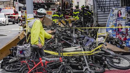 Ein Radfahrer hält an, um einen Stapel von E-Bikes nach einem Brand in Chinatown in New York zu betrachten.