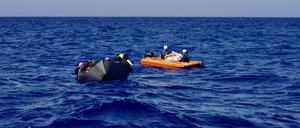 Ein Rettungsboot des Motorsegelschiffs „Nadir“ begleitet ein überfülltes Stahlboot im Mittelmeer.