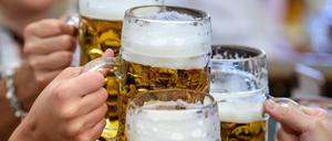 Besucherinnen prosten sich beim Auftakt zum Oktoberfest im Paulaner-Festzelt mit ihrer ersten Maß Bier zu.