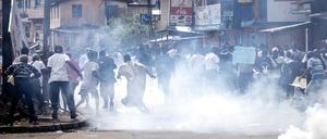 Supporters of the opposition party, All People's Congress (APC), run from teargas during a protest calling for the Chief electoral Commissioner, Mohamed Konneh, to step down after allegations of electoral fraud in Freetown on June 21, 2023. When Sierra Leoneans go to the polls in Saturday's presidential election, he plans to vote for the opposition All People's Congress (APC) party. Last time, he voted for incumbent President Julius Maada Bio of the Sierra Leone People's Party (SLPP) who is running again. (Photo by JOHN WESSELS / AFP)