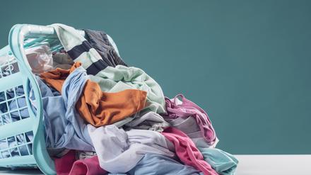Heap of dirty clothes and laundry basket, household and washing concept