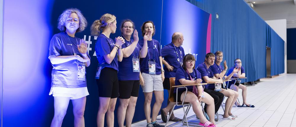 Volunteers helfen bei den Schwimmwettbewerben der Special Olympics.