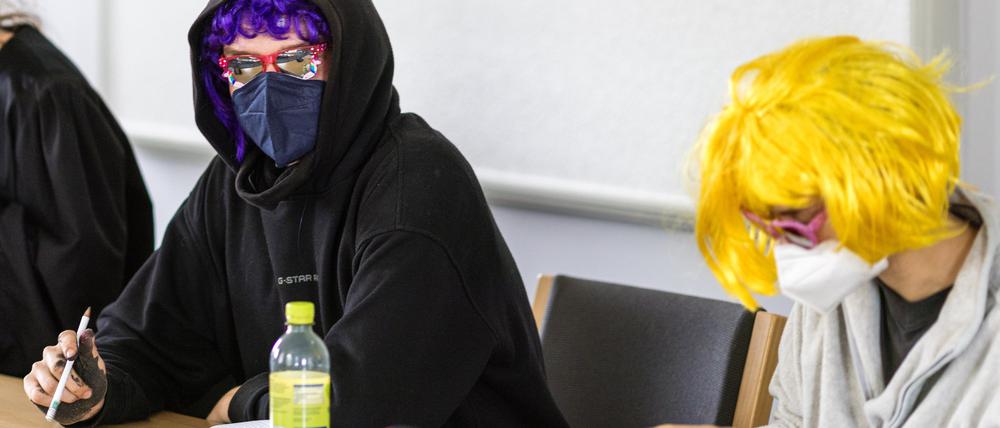 Zwei Kohlekraftgegner, die 2022 an einer Blockade des Kraftwerks Jänschwalde teilnahmen, sitzen zu Beginn eines Berufungsprozesses in einem Verhandlungssaal des Landgerichts Cottbus.