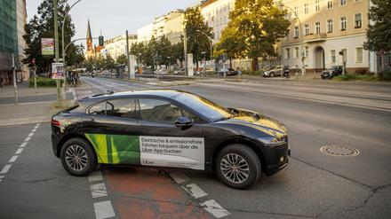 Ein Auto mit Werbung des Fahrdienstleiters Uber fährt in Berlin.