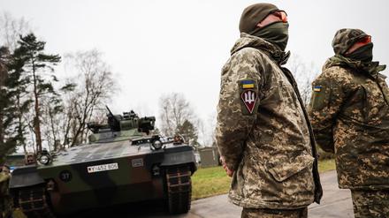 Die Ukrainischen Soldaten Vitalii (r) und Anatolii stehen vor einem Schützenpanzer Marder bei einem Besuch von Bundesverteidigungsminister Pistorius bei der Panzertruppenschule im niedersächsischen Munster.