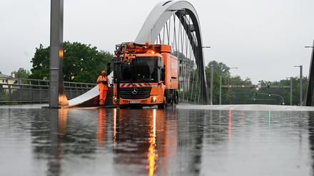 Ein Abpumpfahrzeug der Berliner Stadtreinigung BSR steht auf der überfluteten Freybrücke an der Heerstraße. Aufgrund der starken Regenfälle ist die Straße in Teilen nicht befahrbar.