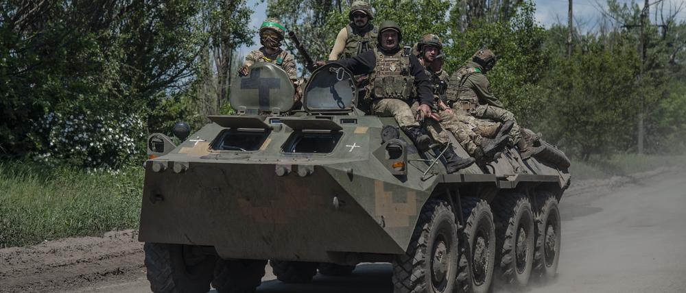 Ukrainische Soldaten fahren auf einem Mannschaftstransportwagen an der Frontlinie.