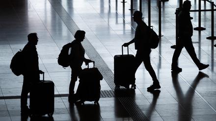 Fluggäste gehen mit Rollkoffern am Flughafen Berlin Brandenburg (BER) „Willy Brandt” durch das Terminal 1. 