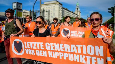 Klimaaktivisten der Letzten Generation beim Slow Walk auf der Karl-Marx-Allee.