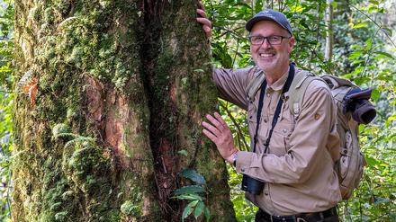 Der Förster Peter Wohlleben steht im ruandischen Nationalpark Nyungwe an einem nach ihm benannten Mahagoni-Baum.