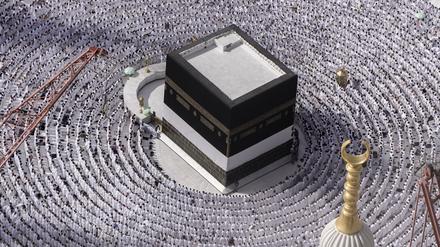 Muslimische Pilger stehen betend um die Kaaba herum.
