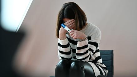 Frau mit einem positiven Schwangerschaftstest.