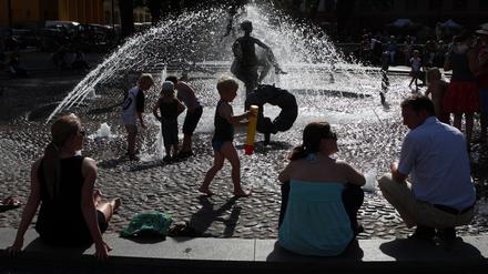 Bei über 30 Grad im Schatten suchen Passanten am Brunnen der Lebensfreude in Rostock nach Abkühlung. Die Hansestadt an der Warnow hat als einzige Großstadt in Mecklenburg-Vorpommern bereits einen Hitzeaktionsplan, um mit häufigeren Hitzeperioden umzugehen. 