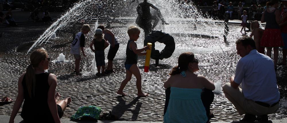 Bei über 30 Grad im Schatten suchen Passanten am Brunnen der Lebensfreude in Rostock nach Abkühlung. Die Hansestadt an der Warnow hat als einzige Großstadt in Mecklenburg-Vorpommern bereits einen Hitzeaktionsplan, um mit häufigeren Hitzeperioden umzugehen. 