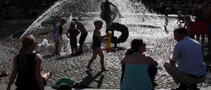 Bei über 30 Grad im Schatten suchen Passanten am Brunnen der Lebensfreude in Rostock nach Abkühlung. Die Hansestadt an der Warnow hat als einzige Großstadt in Mecklenburg-Vorpommern bereits einen Hitzeaktionsplan, um mit häufigeren Hitzeperioden umzugehen.