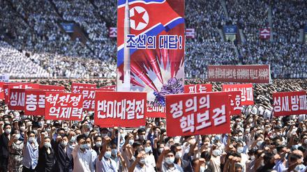 TOPSHOT - In this photo taken on June 25, 2023, residents of Pyongyang hold banners that read "answer of DPRK", "nuclear war deterrent", "anti-US confrontation" and "the nuclear treasured sword of justice" during a mass rally to mark the "Day of Struggle Against US imperialism", on the 73rd anniversary of the three-year Korean War, which began on June 25, 1950, at the Mayday Stadium in Pyongyang. (Photo by KIM Won Jin / AFP)